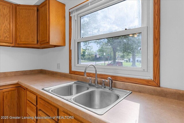 kitchen featuring a sink, brown cabinetry, and light countertops