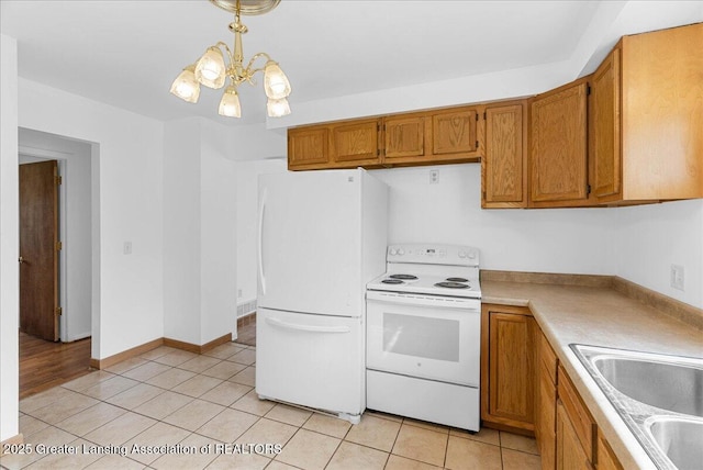 kitchen with white appliances, brown cabinetry, a chandelier, light countertops, and a sink