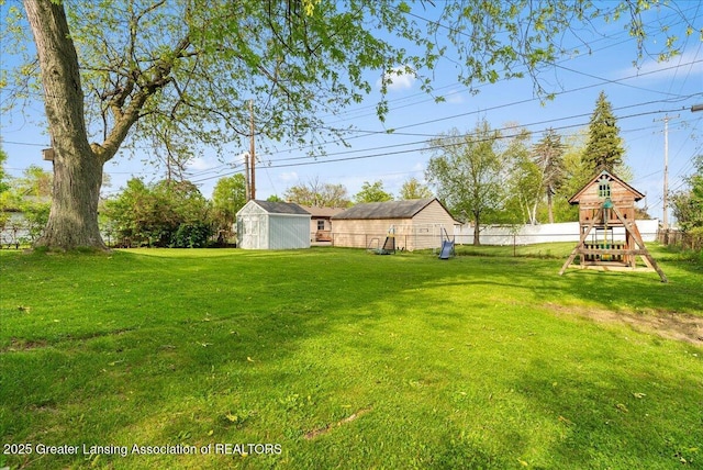 view of yard featuring a playground, a storage shed, and an outdoor structure
