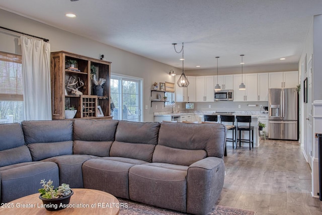 living area with light wood-style flooring and recessed lighting