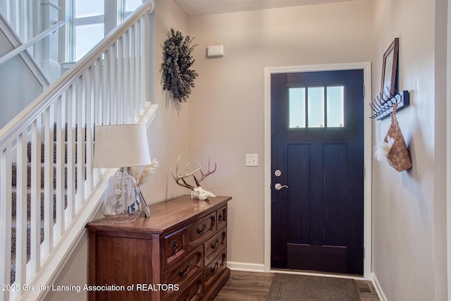 foyer entrance with baseboards and dark wood finished floors
