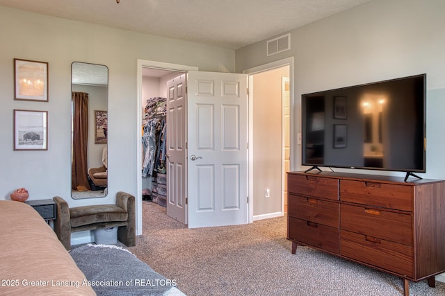 bedroom with carpet flooring, a spacious closet, and baseboards