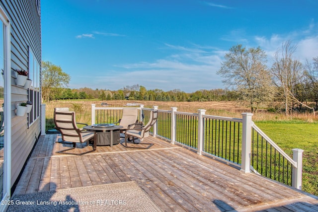 wooden terrace featuring an outdoor fire pit and a lawn