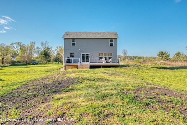 rear view of house with a wooden deck and a yard