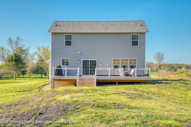 rear view of house with a lawn and a wooden deck
