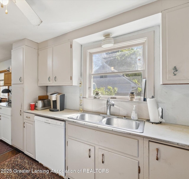 933 W Northrup St, Lansing, MI 48911 - kitchen with dishwasher, a sink, light countertops, and white cabinets