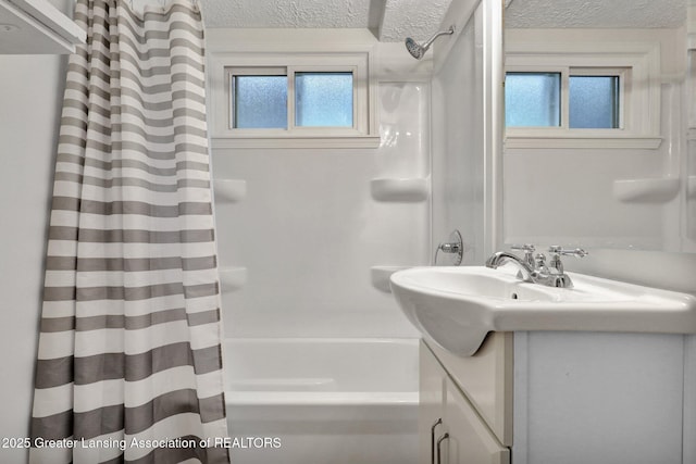 full bath with a textured ceiling, vanity, and shower / bath combination with curtain