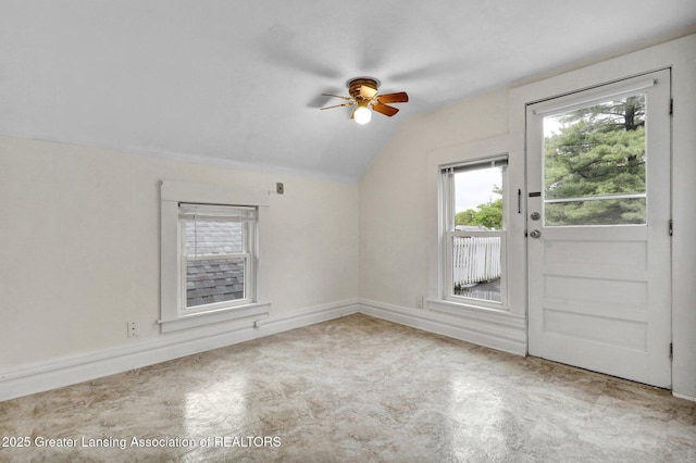 spare room featuring vaulted ceiling, a ceiling fan, plenty of natural light, and baseboards