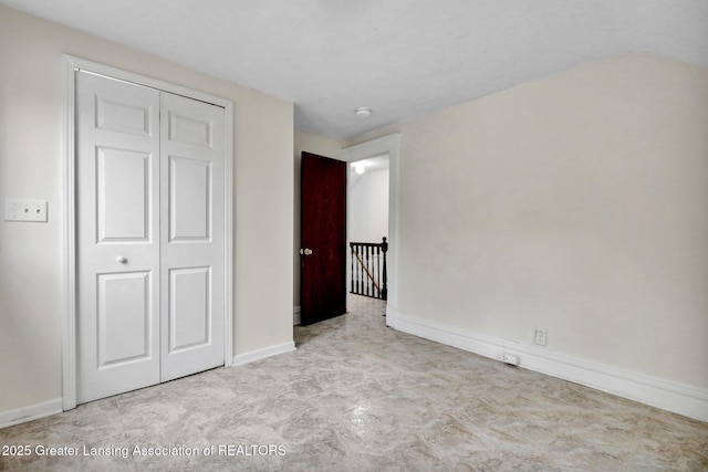 unfurnished bedroom featuring a closet and baseboards
