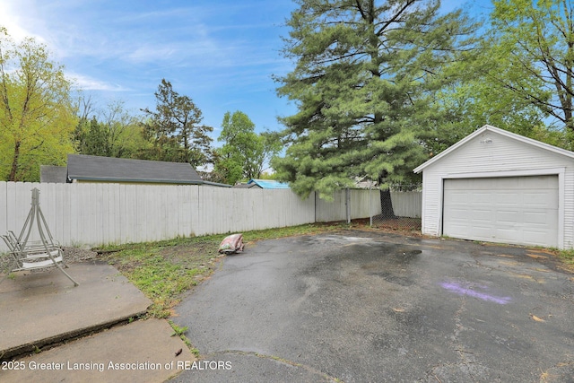 detached garage with fence and driveway