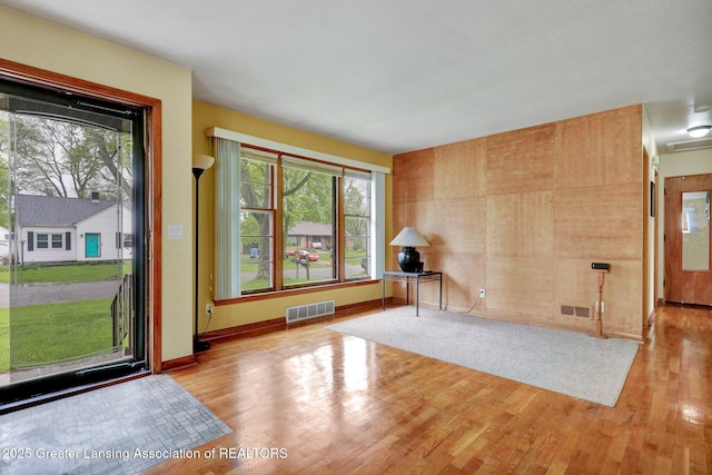 foyer entrance with wood finished floors, plenty of natural light, and baseboards