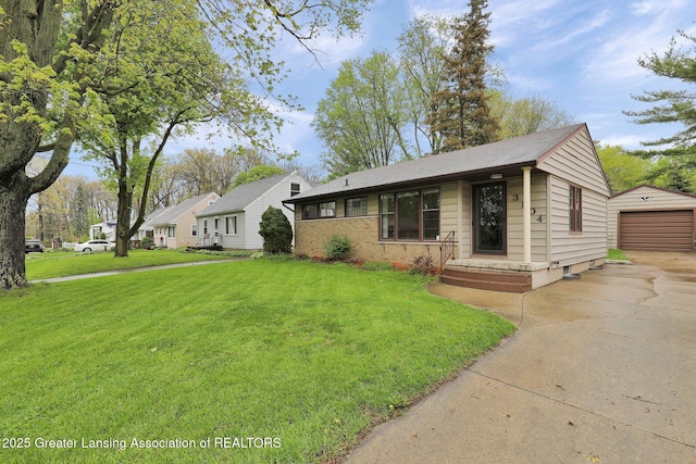 view of front of property featuring driveway, an outbuilding, a front yard, and a detached garage