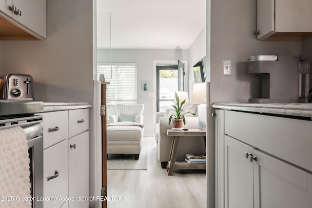 kitchen with light countertops, light wood-style flooring, and white cabinetry