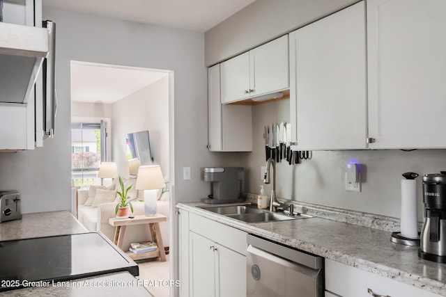 kitchen with stainless steel dishwasher, a sink, light countertops, and white cabinetry