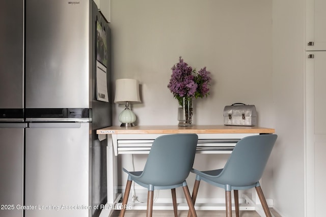 kitchen with freestanding refrigerator, butcher block counters, and baseboards
