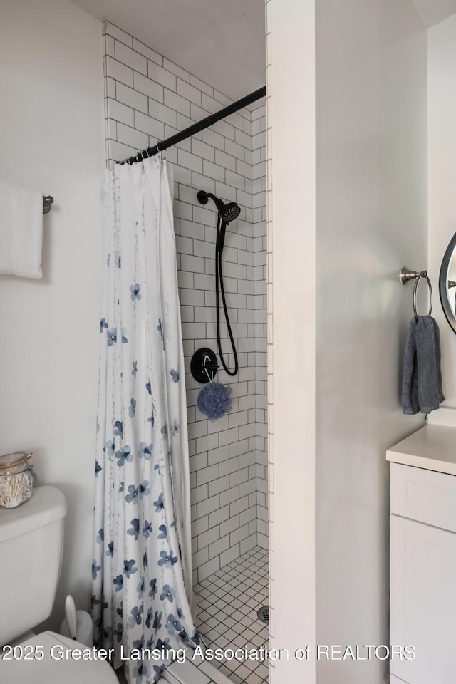 bathroom with a stall shower, toilet, and vanity