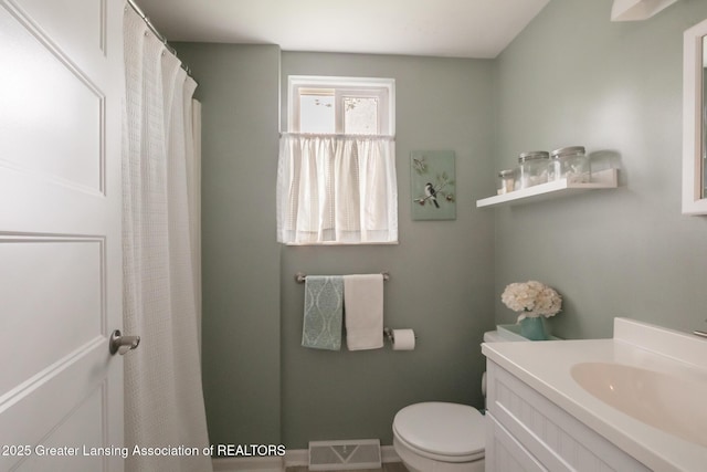 full bathroom featuring toilet, vanity, and a shower with shower curtain