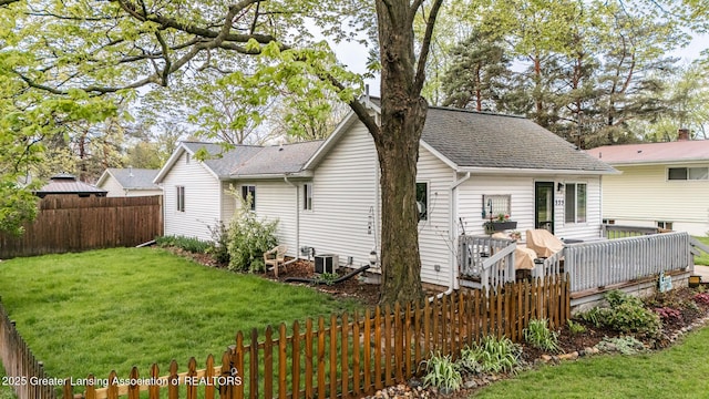 back of property with a deck, roof with shingles, and cooling unit