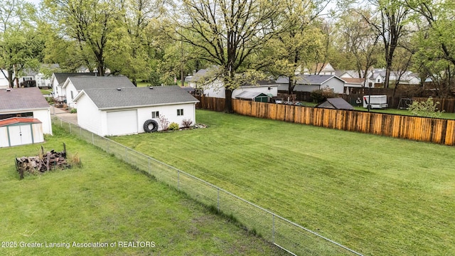 view of yard with a residential view, a storage unit, an outdoor structure, and a garage
