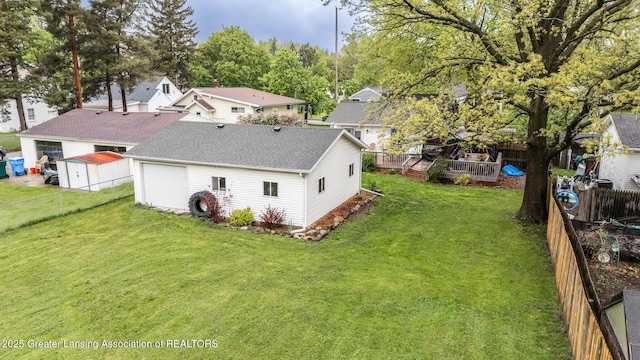 back of property featuring a wooden deck, roof with shingles, and driveway