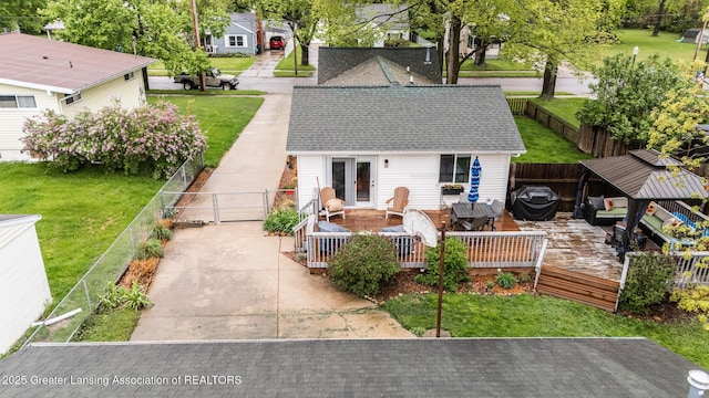 back of property featuring a deck, roof with shingles, a gate, and a residential view