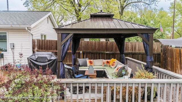 wooden terrace featuring a gazebo, an outdoor living space, and fence