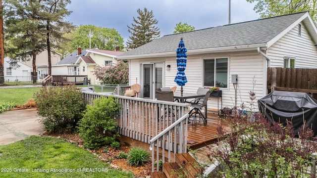 back of house with a deck, a fenced backyard, roof with shingles, and outdoor dining area