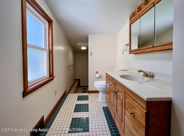 bathroom featuring vanity, toilet, baseboards, and tile patterned flooring