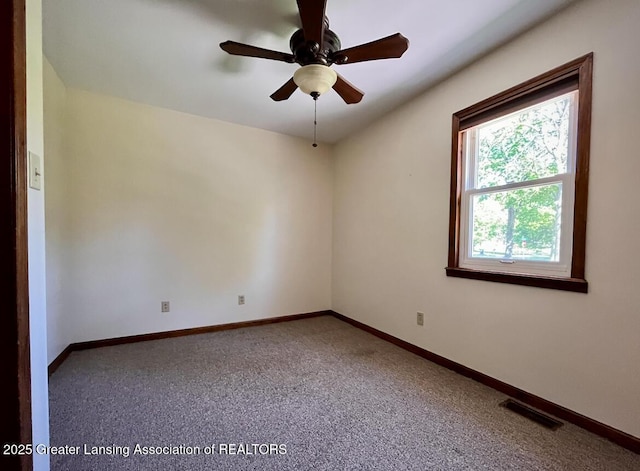 empty room featuring carpet flooring, baseboards, and ceiling fan