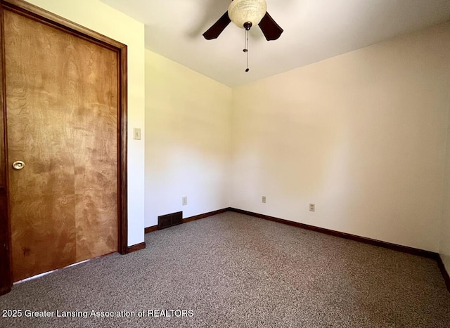carpeted spare room with a ceiling fan and baseboards