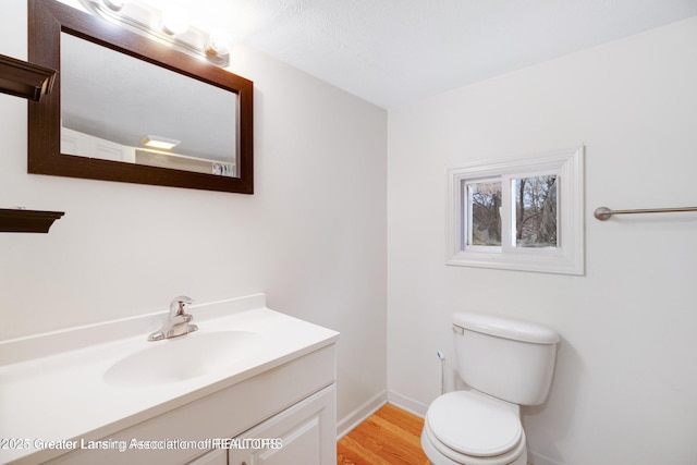 1416 Vermont Ave, Lansing, MI 48906 - bathroom with vanity, toilet, wood finished floors, and baseboards