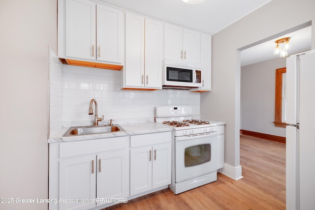 1416 Vermont Ave, Lansing, MI 48906 - kitchen featuring white appliances, a sink, white cabinetry, tasteful backsplash, and light wood-style floors