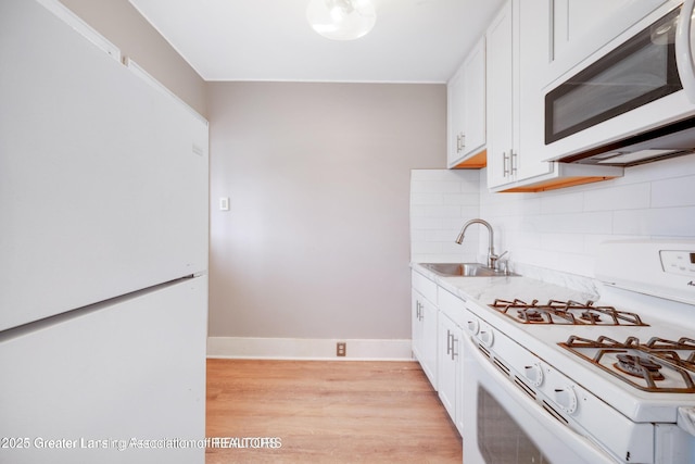 1416 Vermont Ave, Lansing, MI 48906 - kitchen with white appliances, a sink, and white cabinets
