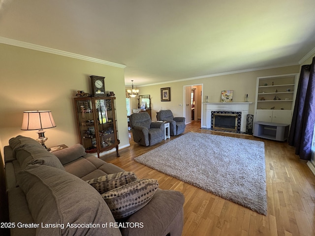 108 S Center St, Eaton Rapids, MI 48827 - living area with a chandelier, ornamental molding, a tile fireplace, and wood finished floors