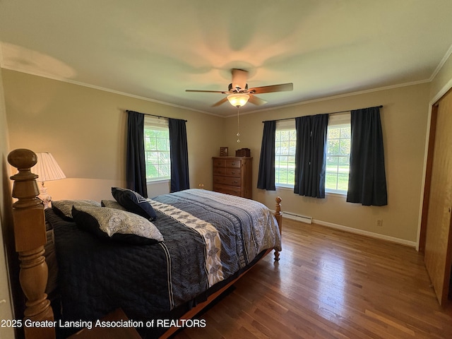 108 S Center St, Eaton Rapids, MI 48827 - bedroom featuring wood finished floors, crown molding, baseboards, a baseboard radiator, and ceiling fan