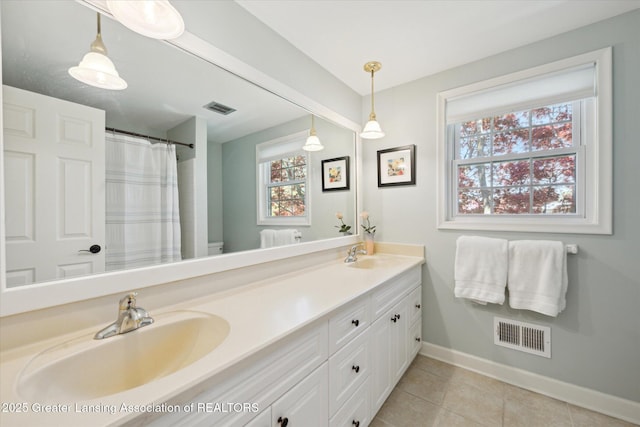 bathroom with baseboards, tile patterned floors, double vanity, and toilet