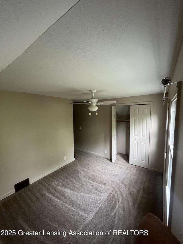 unfurnished bedroom with carpet, a closet, and baseboards