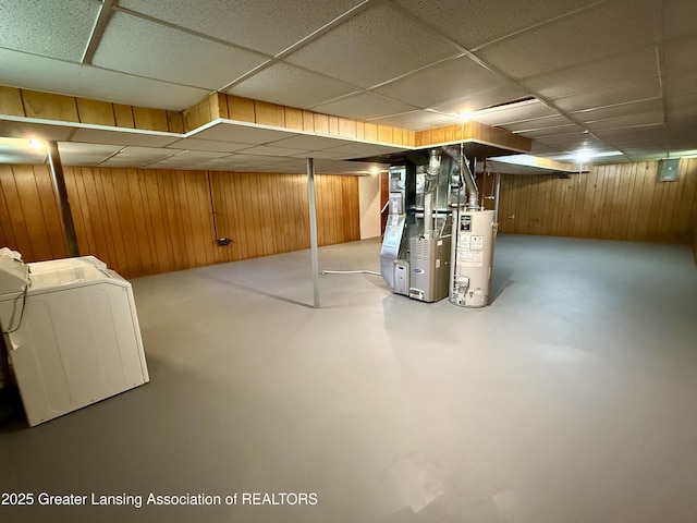 finished basement with gas water heater, wood walls, a drop ceiling, and heating unit