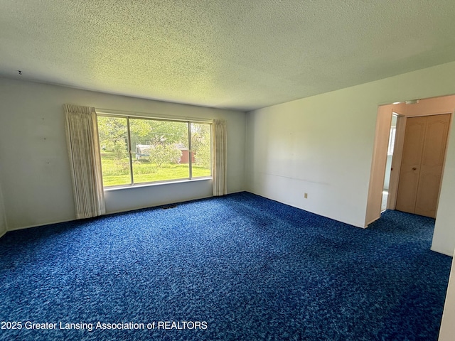 carpeted spare room featuring a textured ceiling