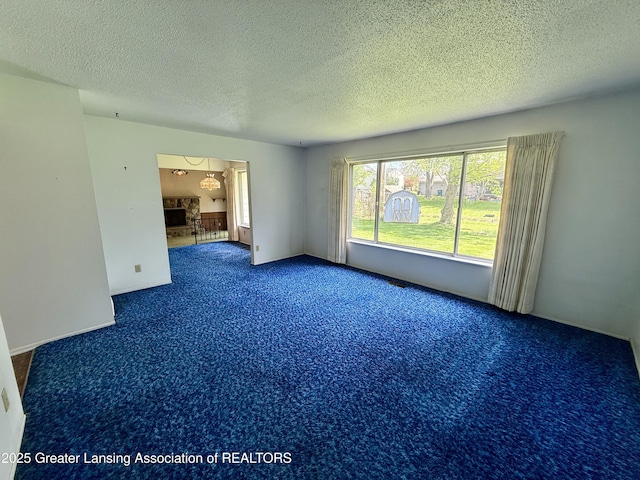 carpeted spare room with a textured ceiling