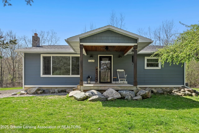 5364 Drumheller Rd, Bath, MI 48808 - view of front of house featuring a porch, a chimney, a front yard, and roof with shingles
