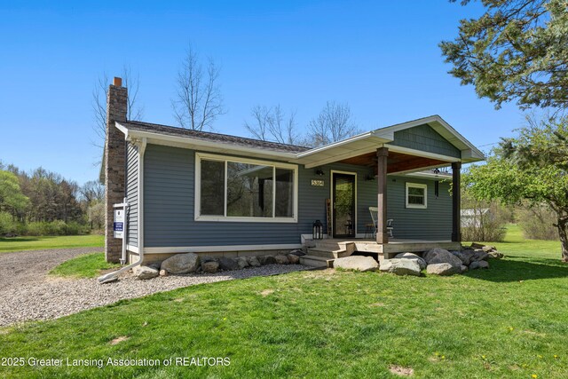 5364 Drumheller Rd, Bath, MI 48808 - view of front of home with a chimney, a porch, and a front lawn
