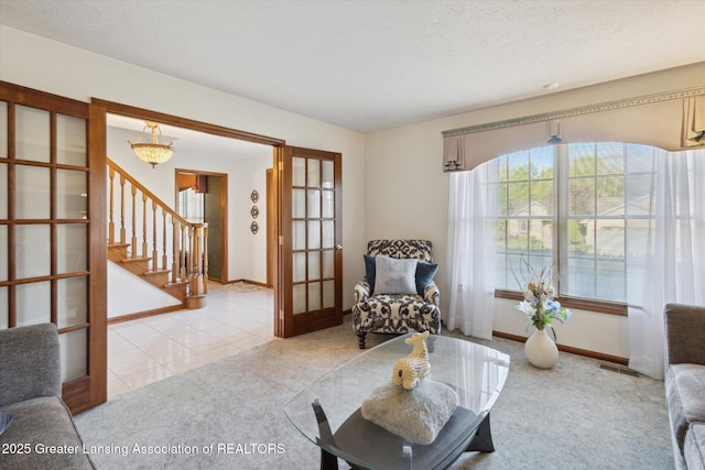 900 Oneida Woods Trl, Grand Ledge, MI 48837 - living area featuring french doors, light carpet, stairs, baseboards, and light tile patterned floors