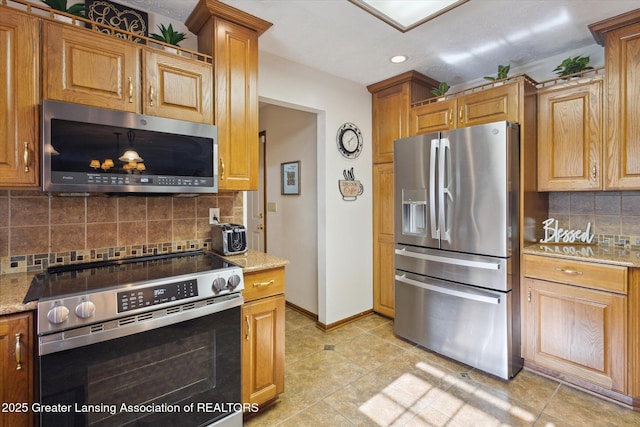 900 Oneida Woods Trl, Grand Ledge, MI 48837 - kitchen with stainless steel appliances, tasteful backsplash, baseboards, recessed lighting, and light tile patterned flooring