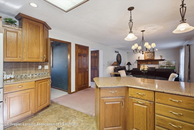900 Oneida Woods Trl, Grand Ledge, MI 48837 - kitchen featuring light stone counters, a chandelier, backsplash, pendant lighting, and recessed lighting