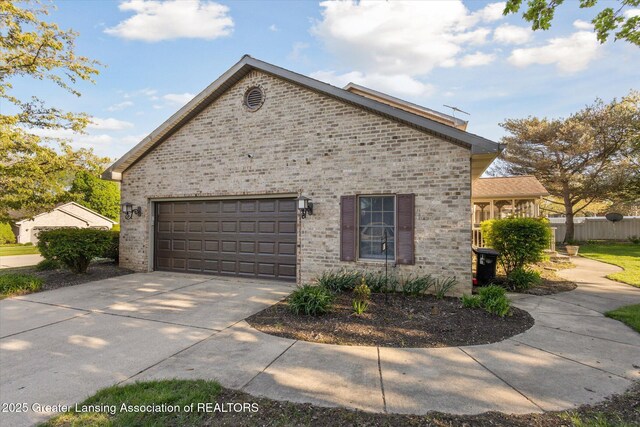 900 Oneida Woods Trl, Grand Ledge, MI 48837 - view of property exterior with driveway, an attached garage, and brick siding