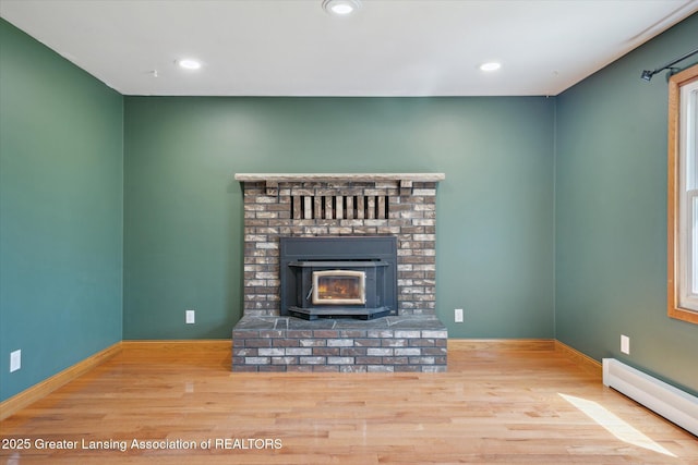 3415 W Needmore Hwy, Charlotte, MI 48813 - unfurnished living room featuring a baseboard heating unit, wood finished floors, recessed lighting, and baseboards