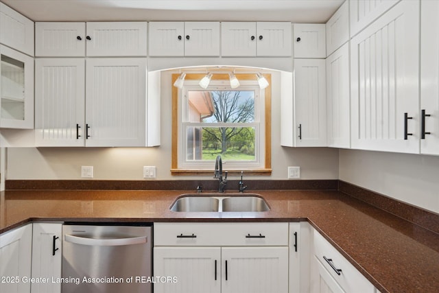 3415 W Needmore Hwy, Charlotte, MI 48813 - kitchen with stainless steel dishwasher, a sink, white cabinetry, dark stone countertops, and glass insert cabinets