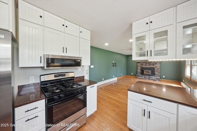 3415 W Needmore Hwy, Charlotte, MI 48813 - kitchen featuring appliances with stainless steel finishes, light wood finished floors, white cabinetry, recessed lighting, and glass insert cabinets