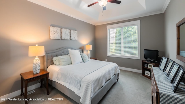 bedroom with carpet, crown molding, baseboards, a tray ceiling, and a ceiling fan